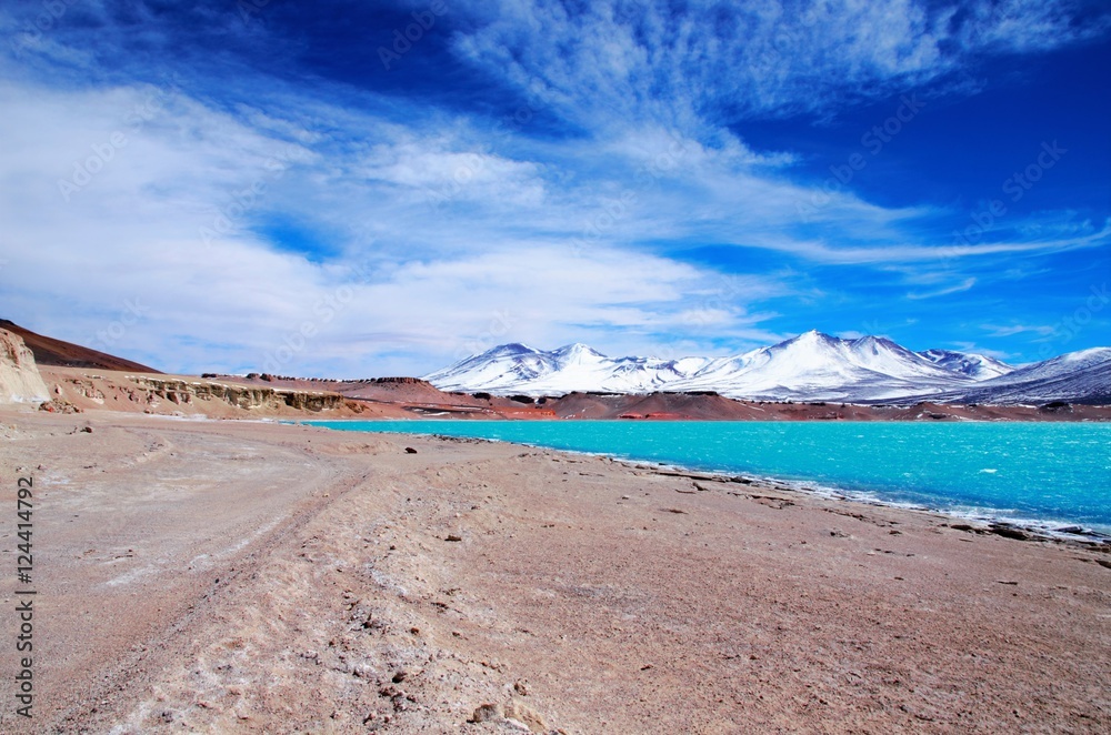 Long shot of the Laguna Verde with turquoise water, mountains in the background and a blue sunny sky in Chile, South America