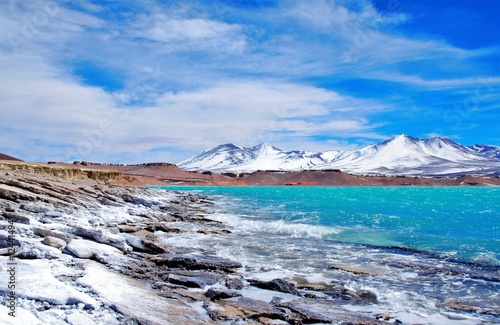 Long shot of the Laguna Verde with turquoise water, mountains in the background and a blue sunny sky in Chile, South America