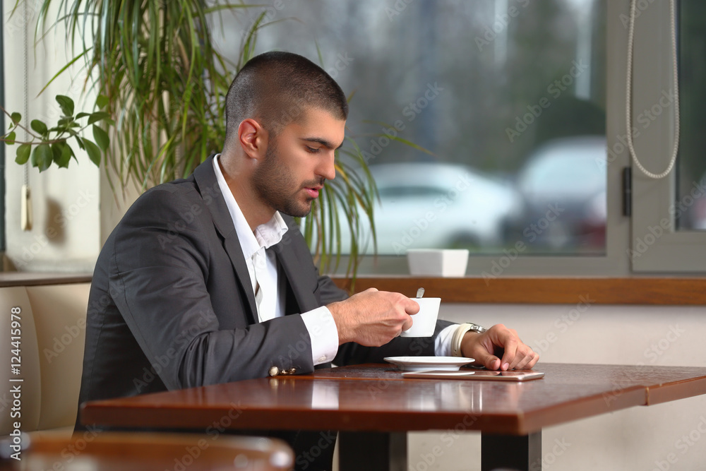 Portrait of handsome young businessman drinking coffee in a restaurant Portrait of handsome young businessman drinking coffee in a restaurant