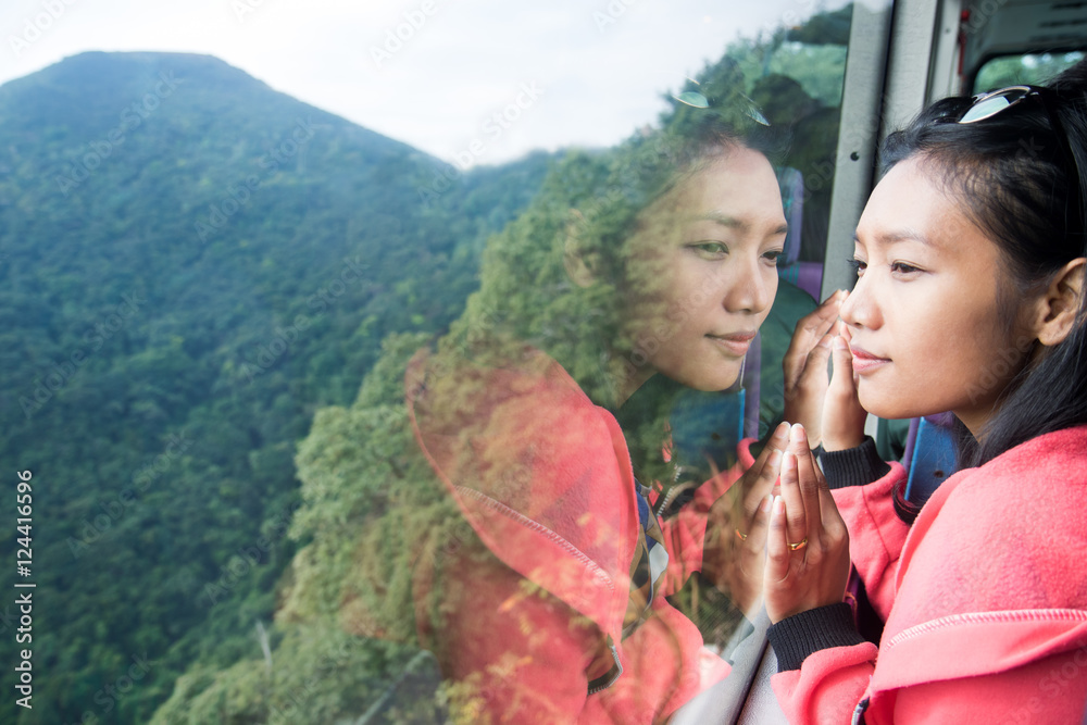 Fototapeta premium woman in a bus looking out the window into the valley