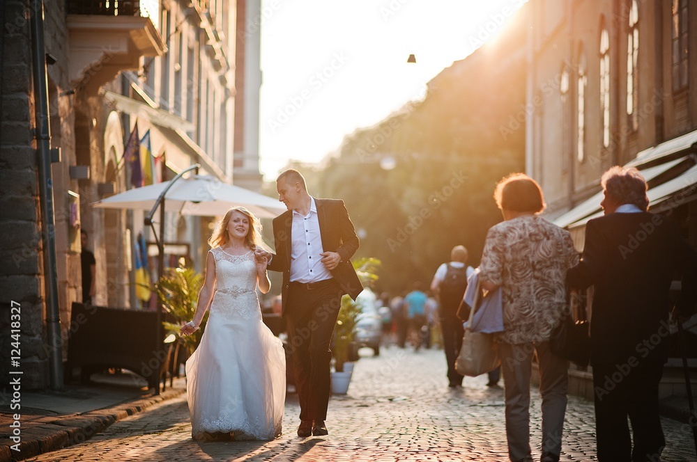 wedding couple walking on sunset streets of city