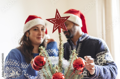 happy family with a young child decorating a christmas tree at h