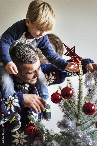 happy family with a young child decorating a christmas tree at h