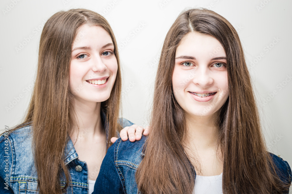 fashion photo of two beautiful young women with long dark hair and bright makeup wears casual clothes,posing in studio fashion photo of two beautiful young women with long dark hair and bright makeup wears casual clothes,posing in studio