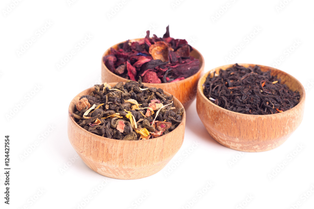 Dry tea in wooden plates, on white background. Leaves of red, green and black tea. Macro photo. Dry tea in wooden plates, on white background. Leaves of red, green and black tea. Macro photo.