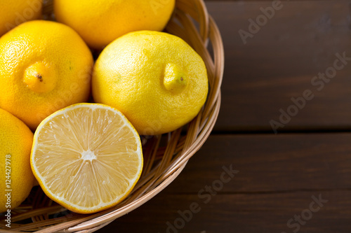lemons in basket on brown wooden surface