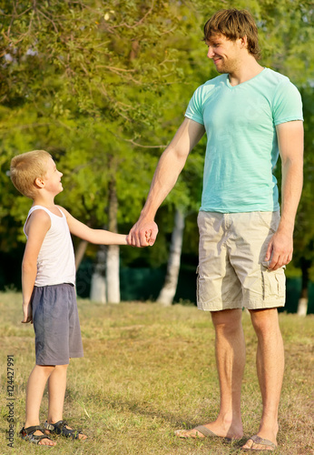 Family Father Man and Son Boy Child holding hand in hand Outdoor Happiness emotion with summer nature on background