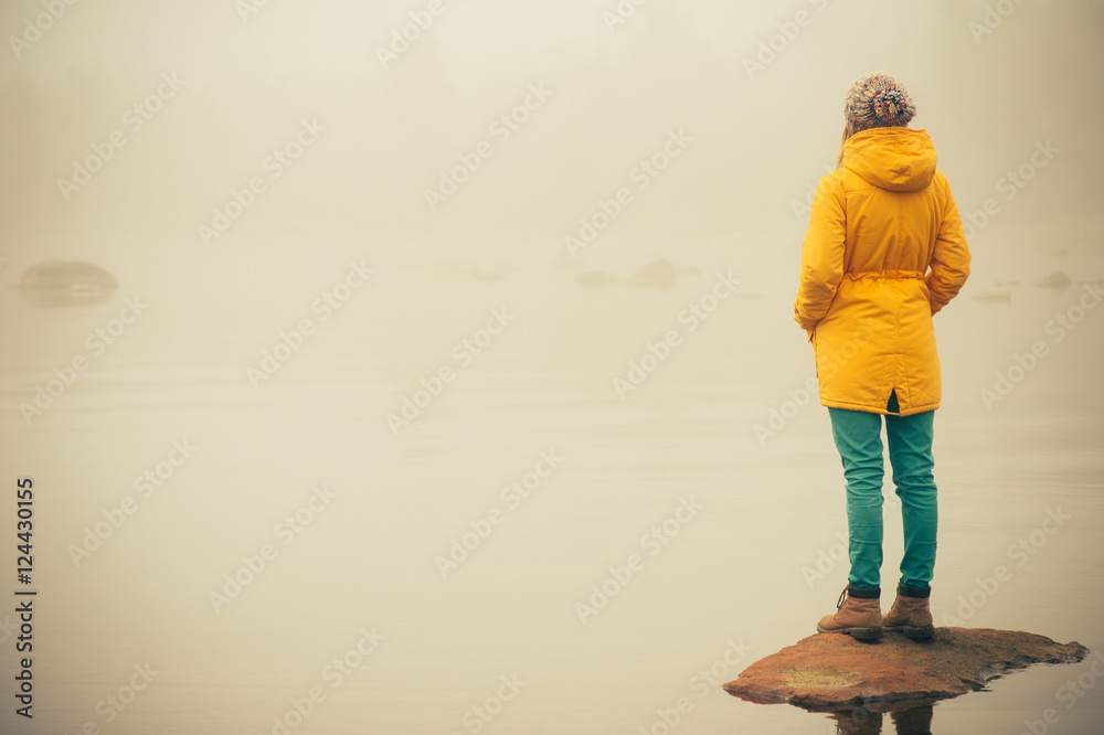 Young Woman standing alone outdoor Travel Lifestyle and melancholy emotions concept winter foggy nature on background Young Woman standing alone outdoor Travel Lifestyle and melancholy emotions concept winter foggy nature on background