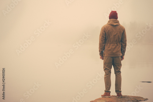 Obraz na plátně Young Man standing alone outdoor with foggy scandinavian nature on background Tr