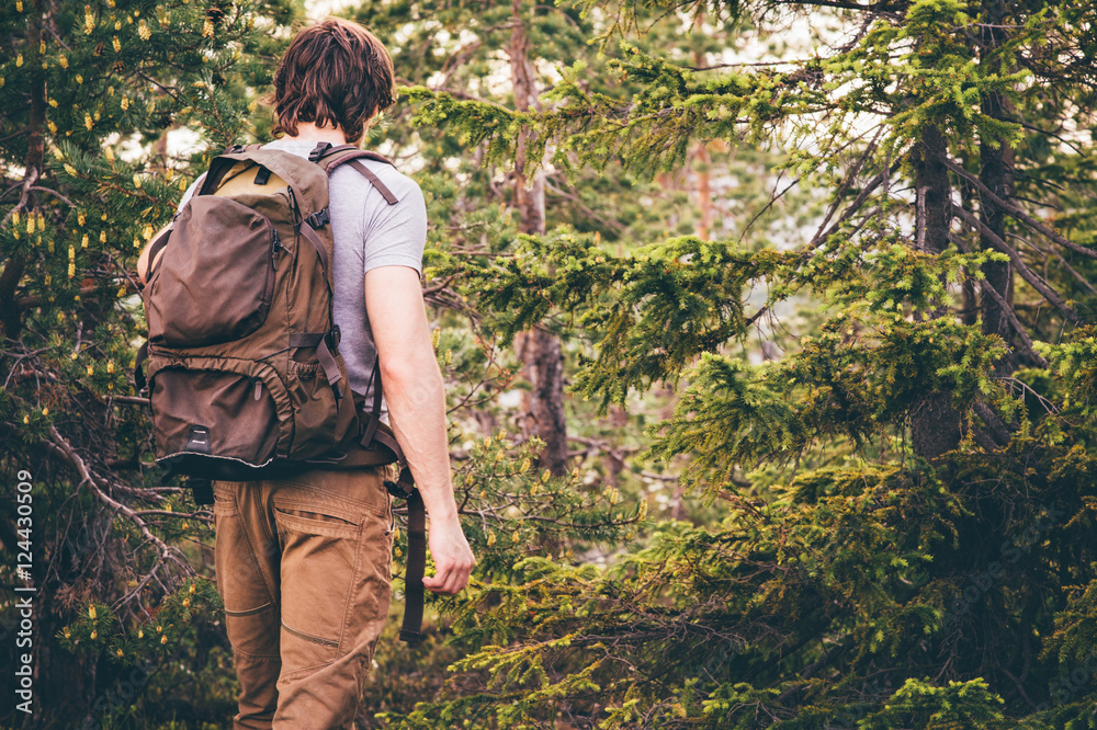 Young Man hiking in forest with backpack Travel Lifestyle and outdoor recreation summer vacations concept Young Man hiking in forest with backpack Travel Lifestyle and outdoor recreation summer vacations concept