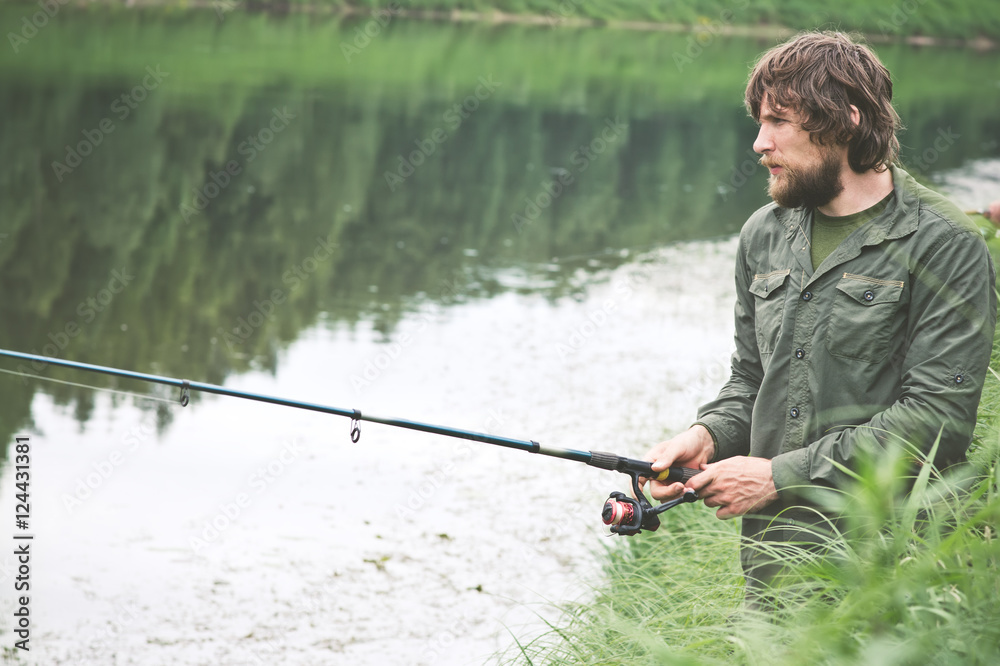 Young Man Fisherman bearded fishing with rod Lifestyle Travel survival concept river on background Young Man Fisherman bearded fishing with rod Lifestyle Travel survival concept river on background