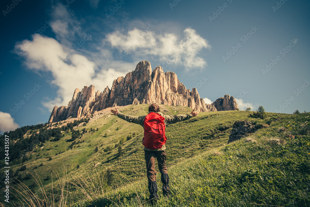Obraz premium Young Man with backpack raised hands relaxing outdoor Travel Lifestyle hiking concept with rocky mountains on background Summer vacations