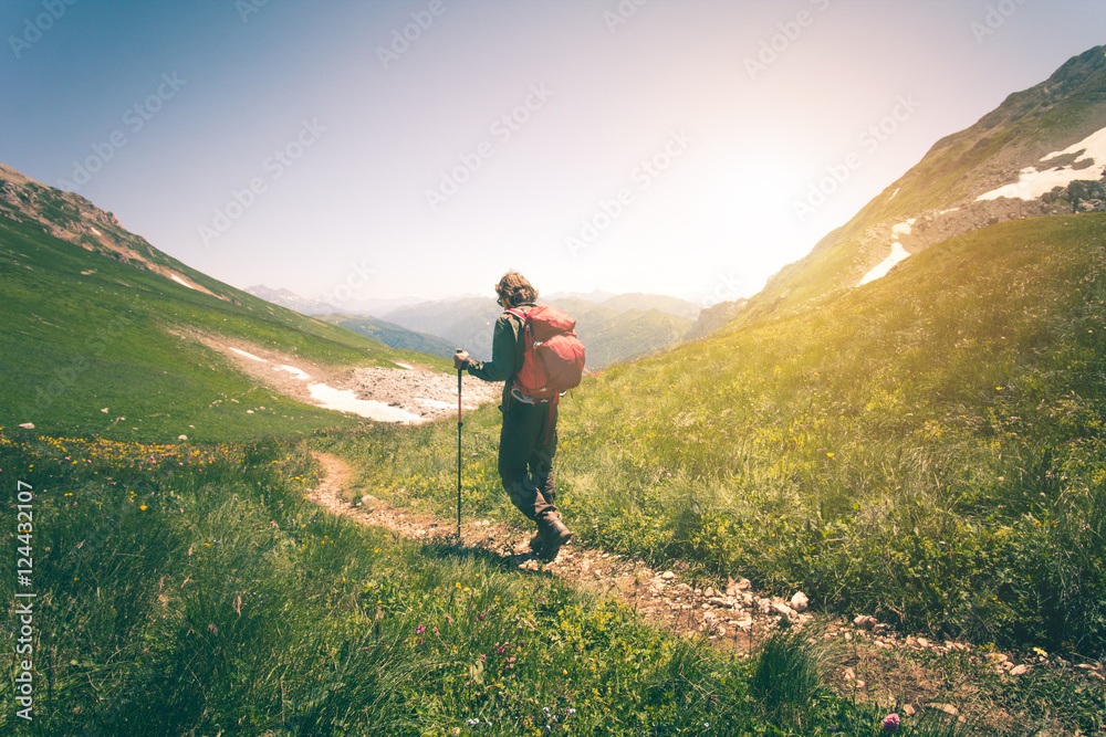 Young Man with backpack hiking outdoor Travel Lifestyle concept mountains on background Summer vacations