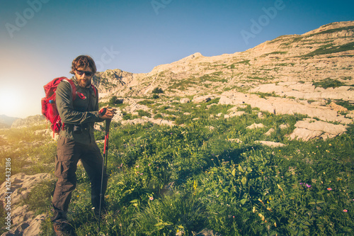 Young Man with backpack mountaineering outdoor Travel Lifestyle concept mountains on background Summer vacations