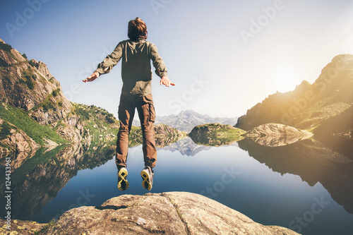 Man jumping Flying levitation with lake and mountains on background Lifestyle Travel happy emotions concept outdoor