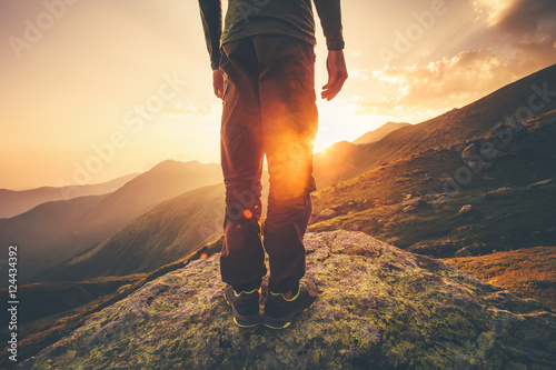 Young Man Traveler feet standing alone with sunset mountains on background Lifestyle Travel concept outdoor