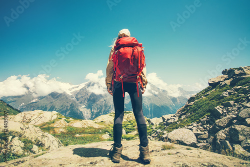 Woman Traveler with red backpack mountains and clouds landscape on background Travel Lifestyle concept adventure summer vacations