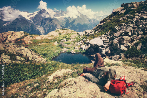Traveler Man laying relaxing with backpack Travel Lifestyle concept serene view mountains landscape on background adventure vacations outdoor © EVERST