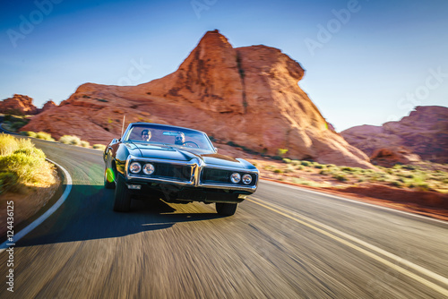 couple driving together in cool vintage car through desert