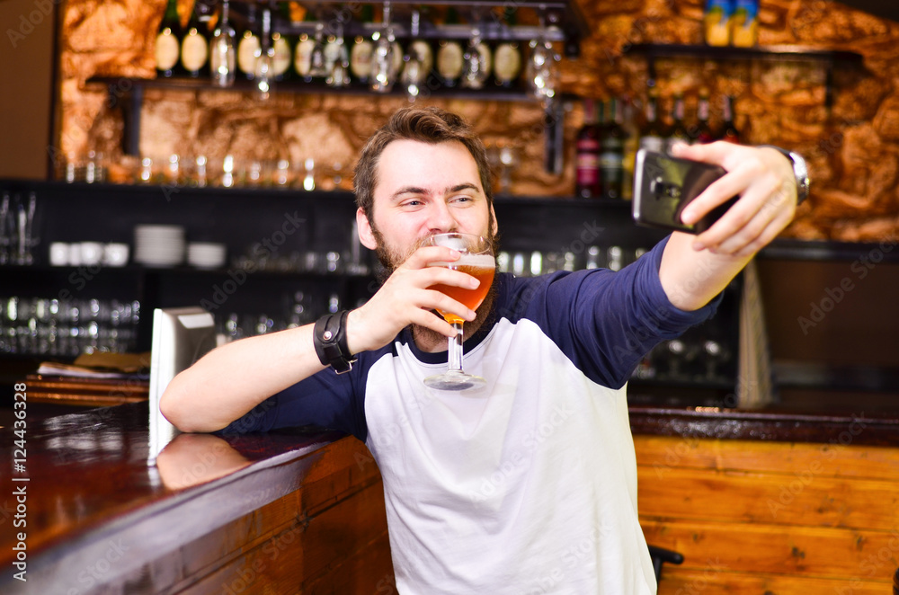The guy makes selfie with beer in hand
