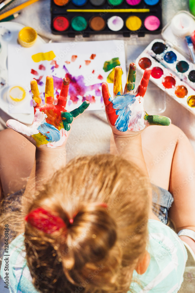 Obraz premium Small girl shows painted colorful hands