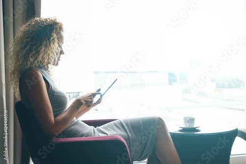 Fotografie An international female student is studying distantly by using a digital tablet during the weekend
