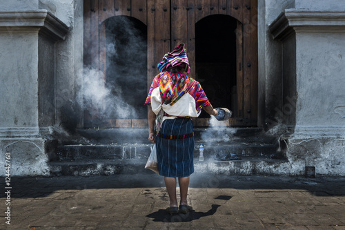 Mayan woman performing a ritual in front of the Santo Tomás church in the town of Chichicastenango, in Guatemala photo