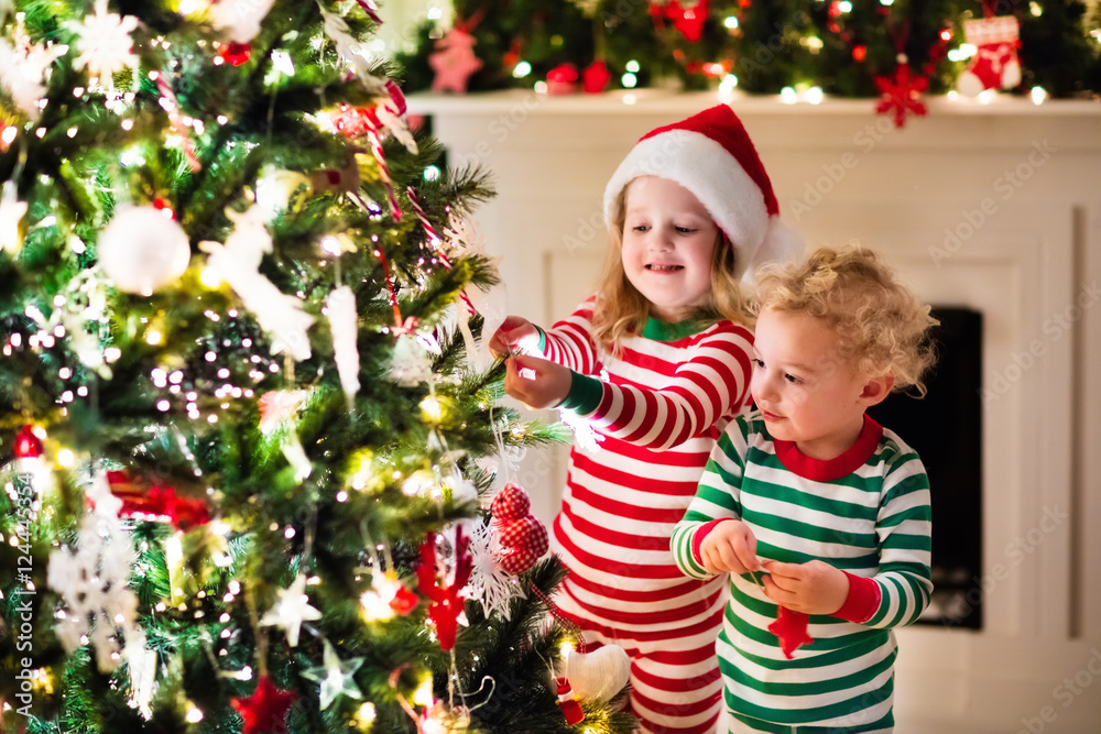 Kids in pajamas under Christmas tree Kids in pajamas under Christmas tree