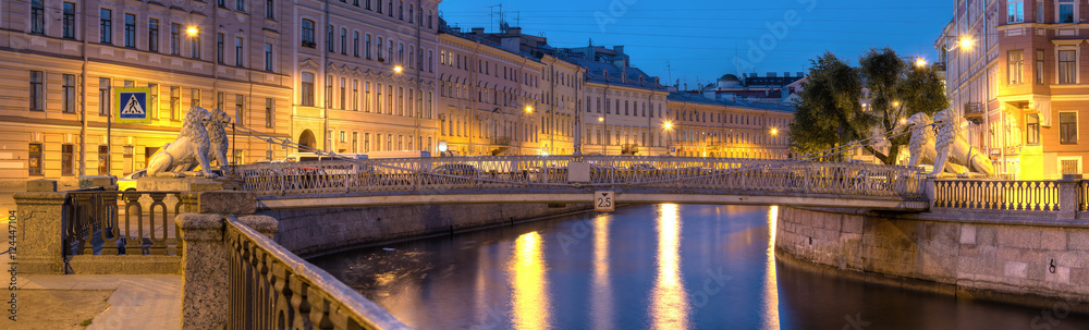 Night view on illuminated Griboedov Canal and Lions Bridge, St. Petersburg, Russia.