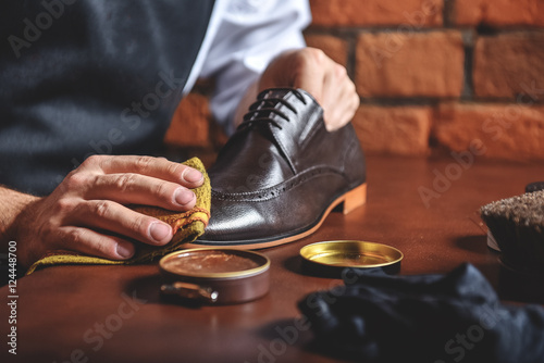 Obraz na plátne man shining shoes with a rag