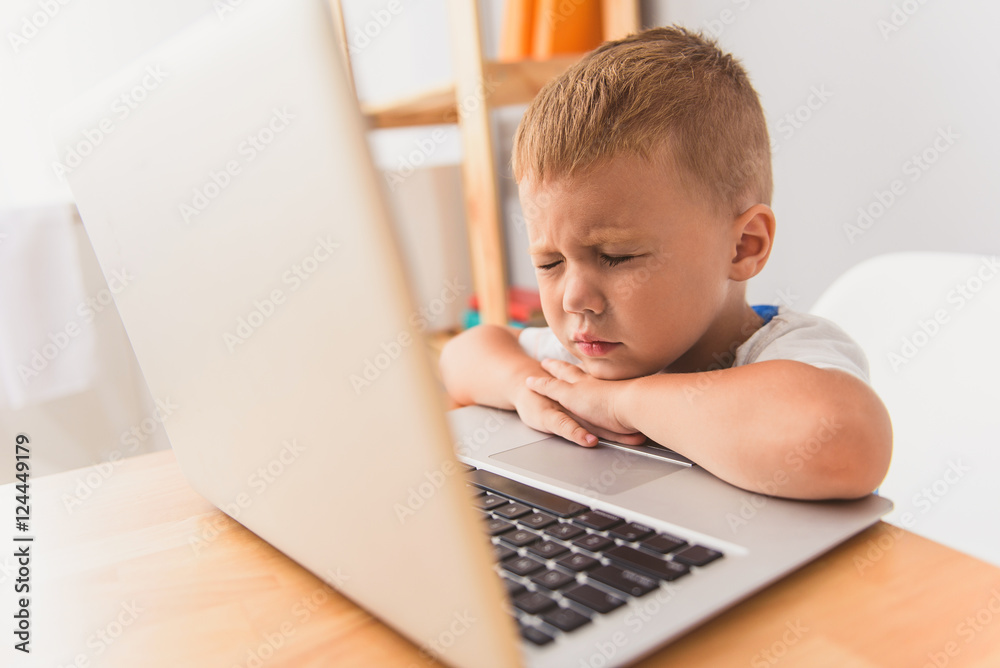 Cute little boy using laptop at home Cute little boy using laptop at home