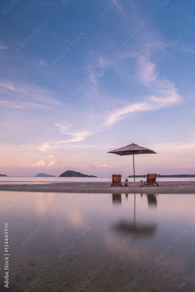 sunset on beach with chairs and umbrella sunset on beach with chairs and umbrella