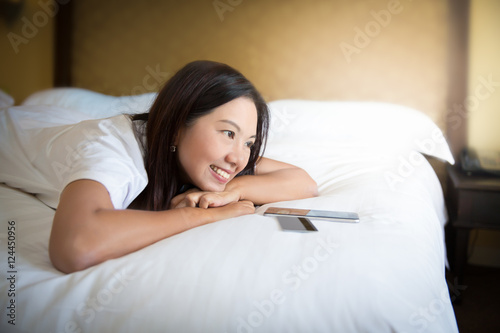 Asian woman using smartphone on bed Woman enjoy shopping online