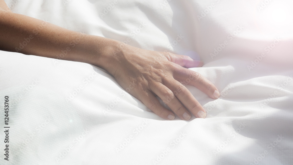 closeup of female arm on white bedsheets closeup of female arm on white bedsheets