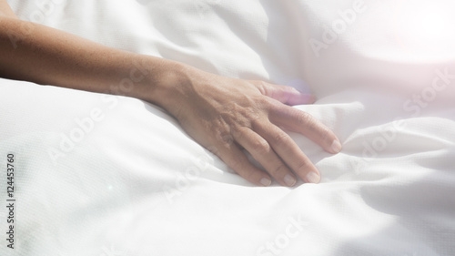 closeup of female arm on white bedsheets © wernerimages
