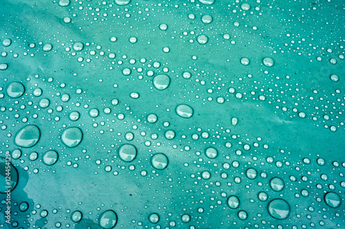 Drops of water on a dusty green color background. Shallow depth of field. Selective focus. Toned.
