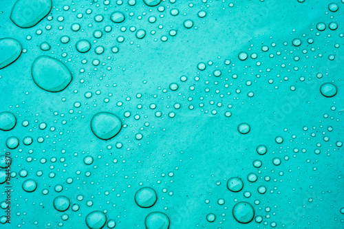 Drops of water on a dusty green color background. Shallow depth of field. Selective focus. Toned.