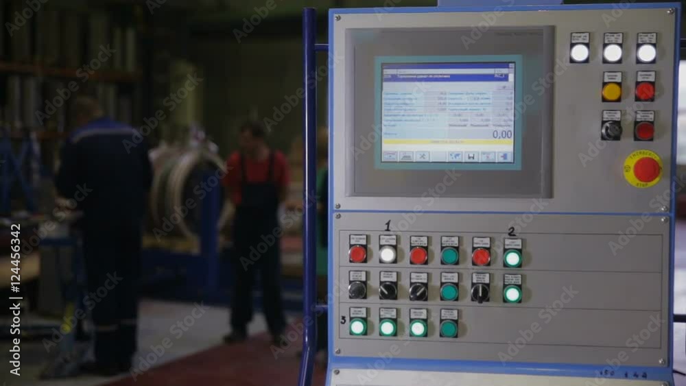 Industrial control panel, display at a modern industrial equipment. Workers operating factory machines at a background. HD. Industrial control panel, display at a modern industrial equipment. Workers operating factory machines at a background. HD.