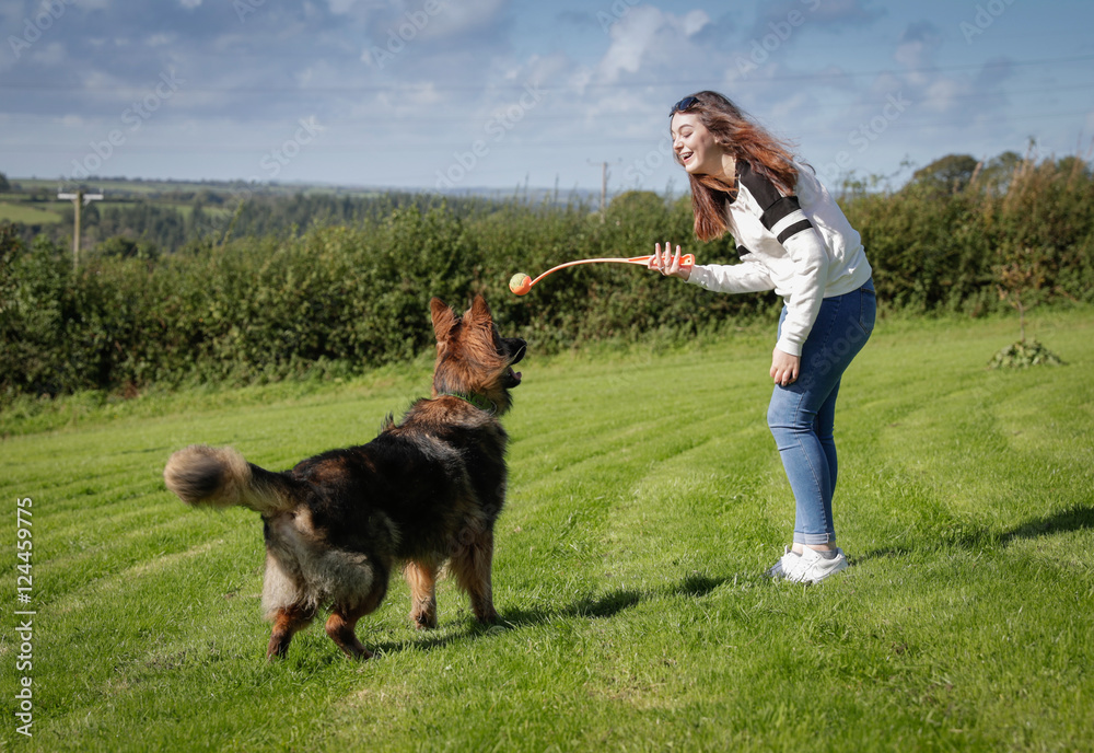 Teenage girl plays with her dog outside in a field Teenage girl plays with her dog outside in a field