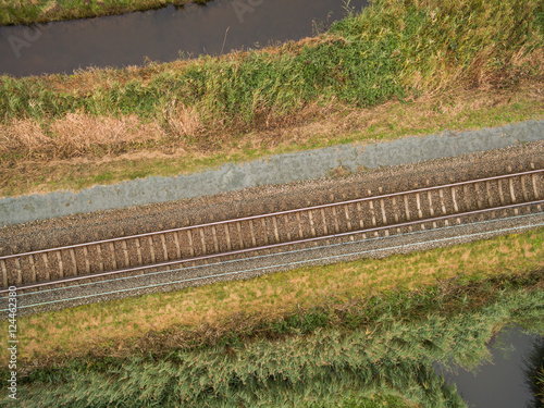 aerial view of green geometric agricultural field with railway in Netherlands 
