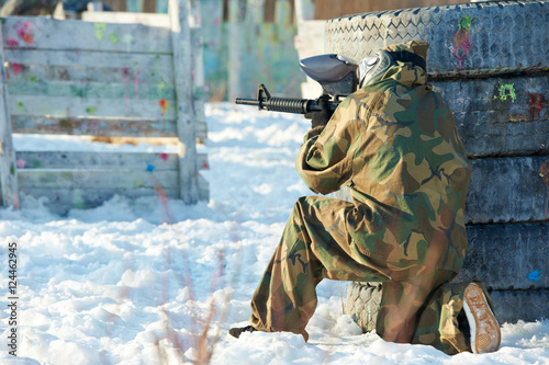 paintball player with marker at winter outdoors