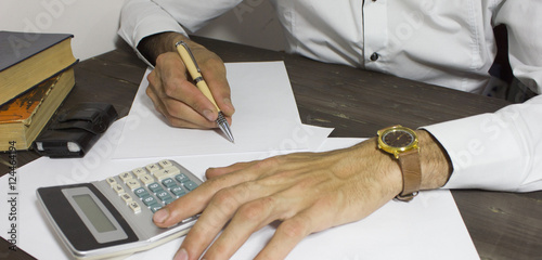 Architecture hand writing blank paper on wooden table with gadge photo