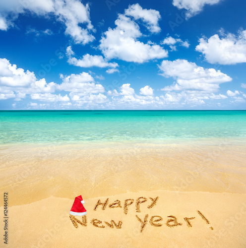 Happy New Year written on a sandy beach