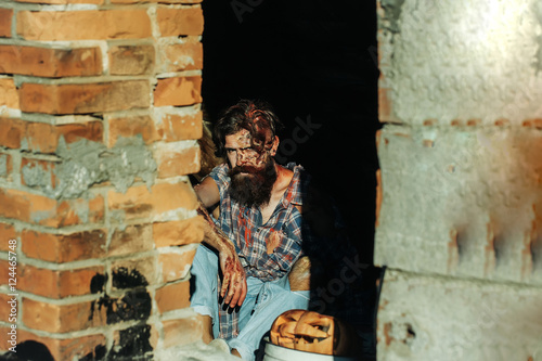 Fototapeta Naklejka Na Ścianę i Meble -  Bearded zombie man with pumpkin
