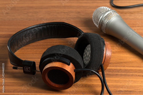 Elegant headphones and a studio microphone on a wooden table. Tools for vocals photo