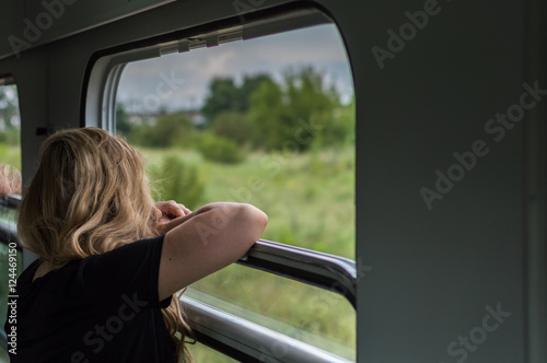 Woman traveling by train and looking through open window