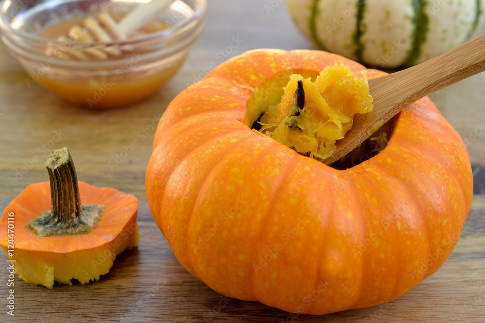 Φωτογραφία Two baked mini-pumpkins stuffed with spiced pumpkin puree, served with honey, on