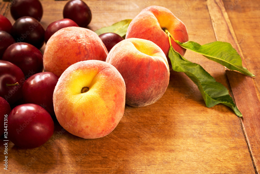 Fresh juicy peaches and plums on the kitchen table Fresh juicy peaches and plums on the kitchen table