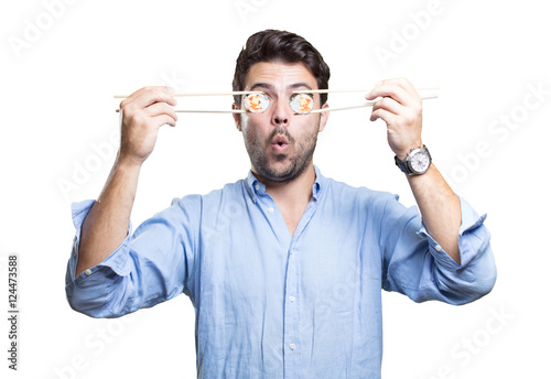 Young man eating sushi on white background