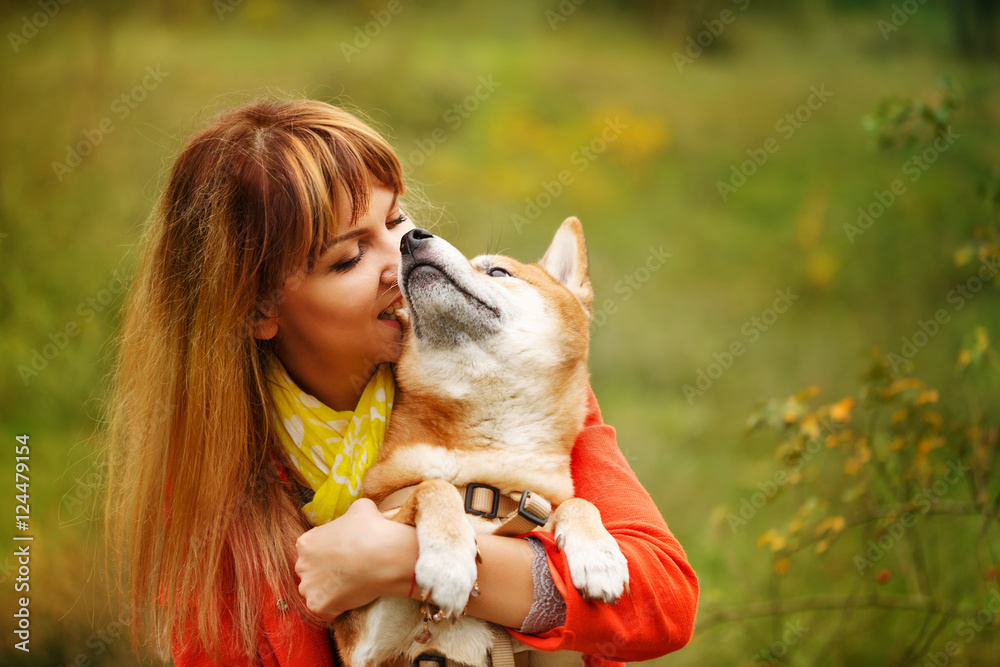 Girl hugging dog Shiba Inu in autumn park. Girl hugging dog Shiba Inu in autumn park.